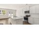 Kitchen featuring white cabinets, center island, stainless steel microwave, and hardwood floors at 325 Silver Moon Dr, Loganville, GA 30052