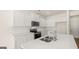 Close up of white kitchen island, stainless steel appliances, and hardwood floors at 325 Silver Moon Dr, Loganville, GA 30052