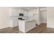 Bright kitchen featuring white cabinets, an island with sink, and hardwood flooring at 325 Silver Moon Dr, Loganville, GA 30052