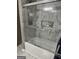 Modern bathroom with marble tile walls and a glass-enclosed bathtub at 785 Ne South Pine St, Conyers, GA 30012
