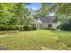 Backyard showcases a well-manicured lawn and a house with many windows, surrounded by lush greenery at 19 Indian Bluff Dr, Sharpsburg, GA 30277