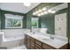 Bathroom featuring double vanity, large mirror, and large garden tub with window at 19 Indian Bluff Dr, Sharpsburg, GA 30277