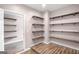 Walk-in closet boasts custom wood shelves with a door leading to another closet, enhancing storage at 19 Indian Bluff Dr, Sharpsburg, GA 30277