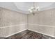 Empty dining room with decorative wallpaper, chair rail, tray ceiling, and hardwood floors at 19 Indian Bluff Dr, Sharpsburg, GA 30277