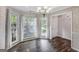 Bright dining room featuring large windows, elegant chandelier, and beautiful hardwood floors at 19 Indian Bluff Dr, Sharpsburg, GA 30277