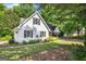 White home with dark shutters, surrounded by lush greenery and a well-kept lawn at 19 Indian Bluff Dr, Sharpsburg, GA 30277