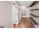 Hallway features hardwood floors, white doors and wood shelving to enhance storage and organization at 19 Indian Bluff Dr, Sharpsburg, GA 30277
