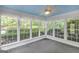 Sunroom with large windows offering serene views and a ceiling fan for comfort and relaxation at 19 Indian Bluff Dr, Sharpsburg, GA 30277