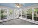Bright sunroom features a ceiling fan, access door and many windows that offer views of the fenced yard at 19 Indian Bluff Dr, Sharpsburg, GA 30277