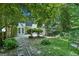 Lush backyard featuring mature trees, stepping stones, and a two-story house in the background at 5490 Chemin De Vie, Sandy Springs, GA 30342