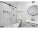 Modern bathroom with a glass shower, tile floors, a round mirror, and a toilet at 5490 Chemin De Vie, Sandy Springs, GA 30342