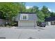 Two-car garage with door to the unit's exterior balcony and black SUV parked to the side on a sunny day at 5490 Chemin De Vie, Sandy Springs, GA 30342