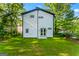 Rear exterior view revealing a modern home, white siding, black trim, and verdant backyard at 1835 Taylor Ave, East Point, GA 30344