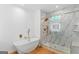 Luxurious bathroom featuring a soaking tub, and glass shower with marble tile and gold fixtures at 1835 Taylor Ave, East Point, GA 30344