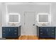 Bathroom featuring double vanities with led mirrors and gold fixtures, centered around a door at 1835 Taylor Ave, East Point, GA 30344