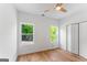 Bright bedroom featuring light wood floors, white walls, two windows, and a ceiling fan at 1835 Taylor Ave, East Point, GA 30344