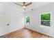 Bedroom features wood-look floors, ceiling fan, two bright windows, and new door at 1835 Taylor Ave, East Point, GA 30344