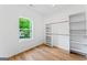 Bright walk-in closet featuring hardwood floors, built in shelving, racks, and window at 1835 Taylor Ave, East Point, GA 30344