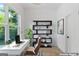Virtually staged office featuring desk, chair, shelving and large window overlooking lush landscape at 1835 Taylor Ave, East Point, GA 30344