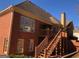 Brick home featuring large windows, deck with stairs, and a serene backyard at 116 Royal Burgess Way, Mcdonough, GA 30253