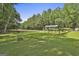 View of horse barn on green lot with trees at 109 Cannon Road, Sharpsburg, GA 30277