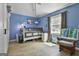 Bedroom with blue walls, hardwood floors, a chair and large window at 109 Cannon Road, Sharpsburg, GA 30277