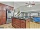 Open kitchen features wooden cabinets, granite countertops, a central island, and stainless appliances at 109 Cannon Road, Sharpsburg, GA 30277