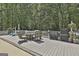 Back deck with outdoor seating, a grill, and serene wooded backdrop, perfect for outdoor dining and relaxation at 109 Cannon Road, Sharpsburg, GA 30277