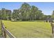 Green pasture with a white fence and a barn surrounded by mature trees at 109 Cannon Road, Sharpsburg, GA 30277