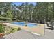 Inviting in-ground pool surrounded by lush landscaping, a wooden deck, and a fenced yard for privacy at 109 Cannon Road, Sharpsburg, GA 30277