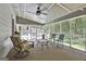 Inviting screened porch with seating, ceiling fan, and views of the outdoor pool and lush greenery at 109 Cannon Road, Sharpsburg, GA 30277