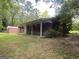 Brick home exterior featuring a covered porch and a lush, green lawn surrounded by mature trees at 2934 Union Grove Rd, Conyers, GA 30012