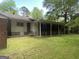 Exterior view of a home with a covered patio, green grass, and surrounding trees at 2934 Union Grove Rd, Conyers, GA 30012
