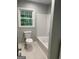 Cozy bathroom featuring a white tub, white tile walls and light green walls at 2934 Union Grove Rd, Conyers, GA 30012