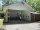 Spacious covered parking area with extra storage and garage doors at the back of the structure at 2934 Union Grove Rd, Conyers, GA 30012
