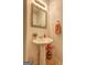 Powder room features a pedestal sink, decorative mirror, and tile floors at 260 Sams Dr, Fayetteville, GA 30214