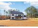 Backyard shot showcasing the expansive lawn and back of house with covered patio at 3735 Tamiami Trl, Cumming, GA 30041