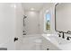 Cozy bathroom featuring a shower-tub, and a bright window at 3735 Tamiami Trl, Cumming, GA 30041