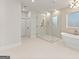 Large Primary bathroom featuring a modern glass shower, white soaking tub, and neutral tiling at 3735 Tamiami Trl, Cumming, GA 30041