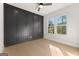 This bedroom features a dark accent wall, hardwood floors, natural light, and a ceiling fan at 3735 Tamiami Trl, Cumming, GA 30041