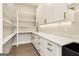 Butler's pantry with open shelving, white cabinets with brass hardware, and black sink at 3735 Tamiami Trl, Cumming, GA 30041