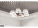A close-up shot of a modern chandelier with white lampshades and a golden frame on a decorative ceiling at 3735 Tamiami Trl, Cumming, GA 30041