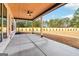 A large covered porch featuring a wooden ceiling, ceiling fan, and concrete floor at 3735 Tamiami Trl, Cumming, GA 30041