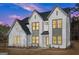 Charming two-story home featuring white brick and contrasting trim under a colorful sky at 3735 Tamiami Trl, Cumming, GA 30041