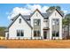 Attractive home with modern design elements, white brick and trim, landscaped yard, and ample windows at 3735 Tamiami Trl, Cumming, GA 30041