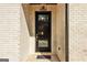 Elegant front door with glass panels, stylish lighting, and brick surround at 3735 Tamiami Trl, Cumming, GA 30041