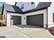 Detached two car garage with dark doors complementing the white home exterior at 3735 Tamiami Trl, Cumming, GA 30041