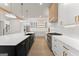 Spacious kitchen featuring a central island, stainless appliances, custom range hood and white cabinets at 3735 Tamiami Trl, Cumming, GA 30041