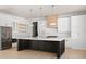 Spacious kitchen features an island, white cabinets, stainless steel appliances, and modern pendant lighting at 3735 Tamiami Trl, Cumming, GA 30041