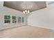 Bright living room featuring hardwood floors, large windows, and a decorative tray ceiling at 3735 Tamiami Trl, Cumming, GA 30041